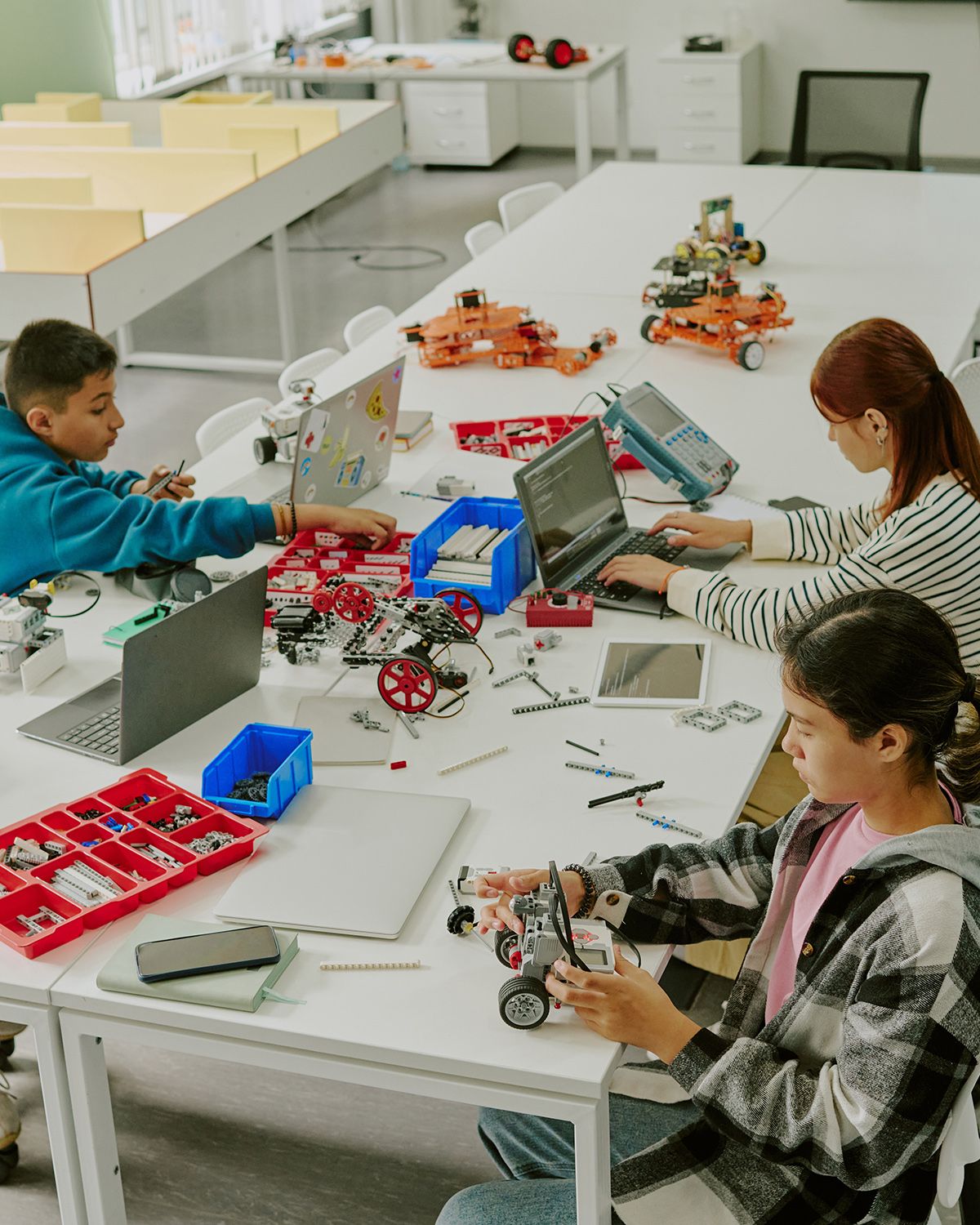 a full timetabled class of 24 students building at desks in a normal classroom, not a makerspace