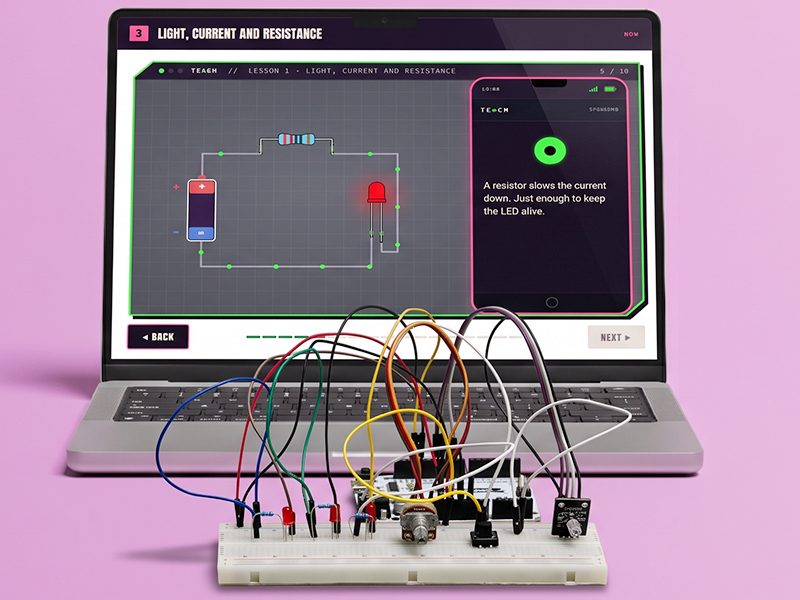 A 28 Days lesson on a laptop beside a student's breadboard build