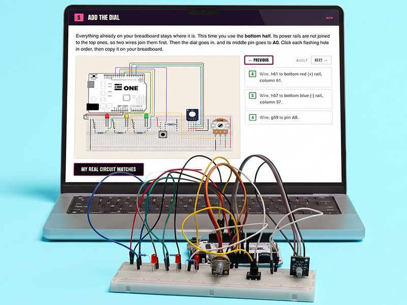 A 28 Days wiring step on a laptop beside the breadboard it describes