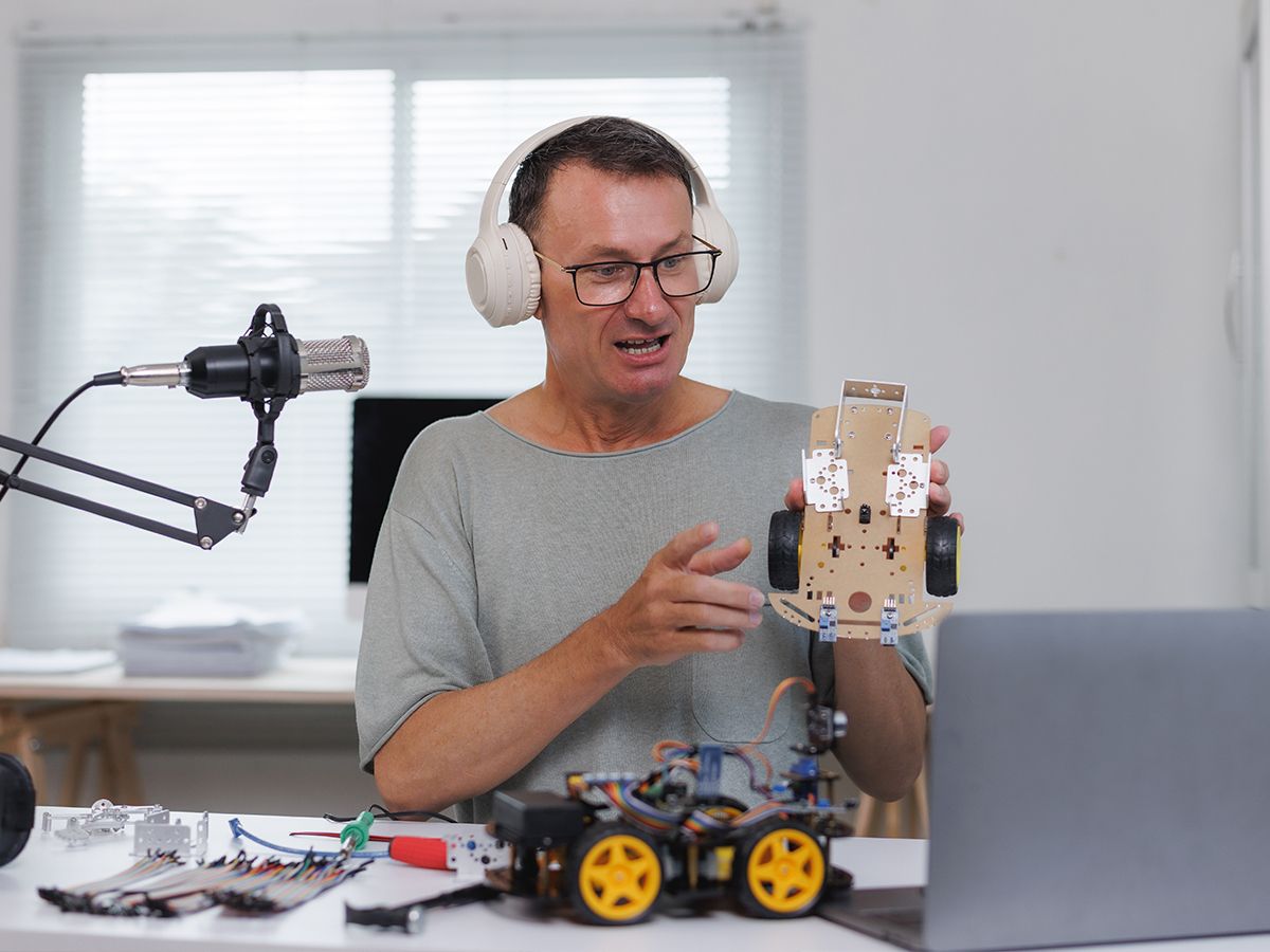 a teacher on a video call with a Bolt trainer, a kit open on the desk beside the laptop